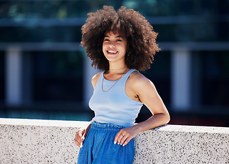 Image showing Portrait, fashion and city with a black woman outdoor on a bridge, looking relaxed during a summer day. Street, style or urban and an attractive young female posing outside with an afro hairstyle