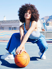 Image showing Portrait, fashion and basketball with a black woman outdoor on a sports court for urban or street style. City, fitness or style and an attractive young female posing outside with a ball for lifestyle