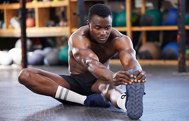 Image showing Stretching. fitness and health with black man in gym for sports, workout and performance. Wellness, exercise and training with athlete and warm up legs on floor for cardio, endurance and energy