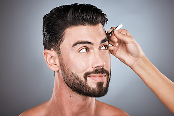 Image showing Face, barber and man with tweezers in studio isolated on a gray background for wellness. Thinking, hair removal and male model with facial product to pluck eyebrows for grooming and beauty at salon.