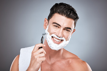 Image showing Razor, face and man with shaving cream in studio isolated on a gray background. Beard, towel and portrait of happy male model with facial product, foam or gel to shave for wellness and hair removal.