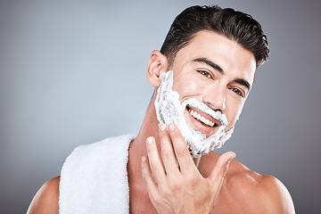 Image showing Applying, shaving and portrait of a man with cream on face isolated on a grey studio background. Happy, hygiene and headshot of a person with a facial product for beard hair removal on a backdrop