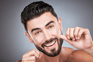 Image showing Dental floss, teeth and portrait of man in studio for beauty, healthy body and hygiene on background. Male model, tooth flossing and cleaning mouth for facial smile, fresh breath and happy cosmetics