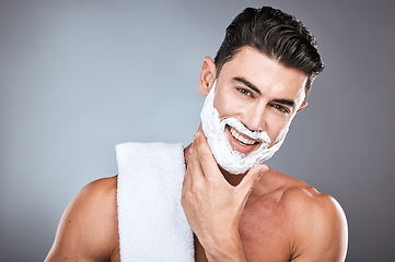 Image showing Portrait, shaving cream and grooming with a man model in studio on a gray background for hair removal. Face, hand and skincare with a handsome young male in the bathroom for a shave in the morning