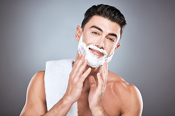 Image showing Portrait, shave cream and grooming with a man model in studio on a gray background for hair removal. Face, hand and skincare with a handsome young male in the bathroom for shaving in the morning