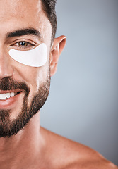 Image showing Half, face and man with eye patch in studio isolated on a gray background for wellness. Portrait, skincare or male model with cosmetics, facial treatment or product for eyes, wellness or healthy skin