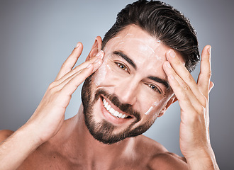 Image showing Skincare, face and man with cream in studio isolated on a gray background for facial wellness. Portrait, dermatology cosmetics and happy male model apply lotion, creme or moisturizer for healthy skin