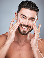 Image showing Portrait, skincare and man with cream in studio isolated on a gray background for facial wellness. Face, dermatology cosmetics or happy male model with lotion, creme or moisturizer product for health