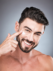Image showing Skincare, clean and portrait of a man with face cream isolated on a grey studio background. Beauty, grooming and model applying facial sunscreen for body dermatology, hygiene and sun protection