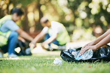 Image showing Volunteer hands, plastic and pollution while cleaning park for community service for environment and recycling. People group helping with bottle and trash bag outdoor on grass for ngo clean project