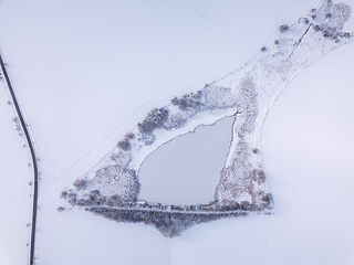 Image showing Aerial bird view of beautiful winter landscape with frozen pond covered with snow. Central european countryside. Czech Republic, Vysocina Highland region, Europe