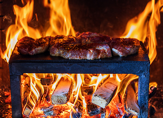 Image showing pork steaks preparing on the on a stone plate