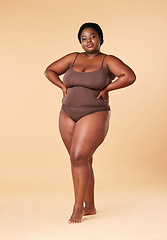 Image showing Portrait, wellness and plus size with a model black woman posing hands on hips in studio on a beige background. Beauty, underwear and natural with a female sitting on a stool for body positivity