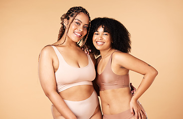 Image showing Skincare, beauty and black women friends in underwear in studio isolated on a brown background. Empowerment portrait, lingerie and body positive happy girls with makeup, cosmetics and healthy skin.