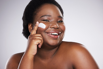 Image showing Portrait, skincare and cream with a model black woman in studio on a gray background for plus size beauty. Face, skin and lotion with an attractive young female indoor to apply facial treatment