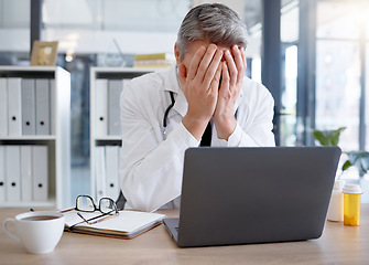 Image showing Doctor, burnout and man with stress in hospital feeling depressed while working on laptop. Mental health, depression and medical professional or physician with headache, pain and anxiety in clinic.