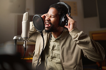 Image showing Music, streaming and man recording in studio in home, singing into microphone with headphones and talent. Technology, art and creative influencer or musician with live stream song for record label.