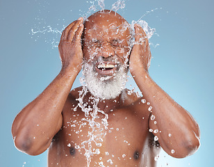 Image showing Water splash, skincare and black man isolated on blue background for face cleaning, beauty and using hands. Happy senior model or person with facial wash or hygiene for dermatology in studio action