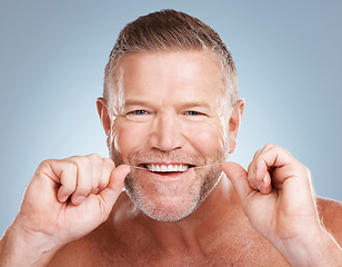 Image showing Floss, portrait and man with dental health for fresh breath, hygiene and cleaning teeth against blue studio background. Oral health, male and string for mouth, morning routine or grooming on backdrop