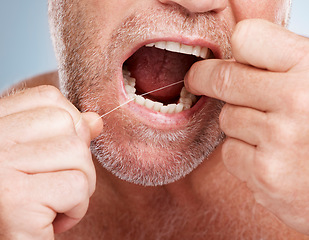 Image showing Hands, dental and mouth of man with floss in studio isolated on a gray background for health. Oral hygiene, wellness and senior male model with thread or string for flossing, cleaning or teeth care.