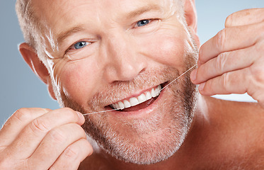 Image showing Face portrait, dental and with man with floss in studio isolated on a gray background for health. Oral hygiene, wellness and happy senior male model with thread for flossing, cleaning or teeth care.