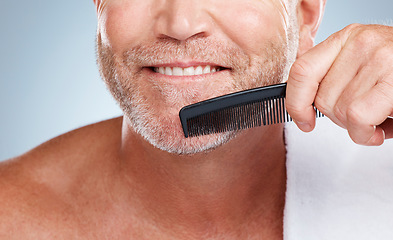 Image showing Skincare, grooming and man brush beard for wellness, healthy skin and hygiene on blue background. Barber aesthetic, cleaning and face zoom of male with comb for facial treatment, beauty and hair care