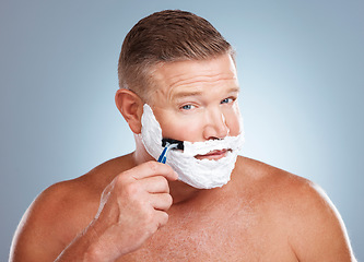 Image showing Shaving cream, face and man with razor in studio isolated on a gray background for hair removal. Portrait, skincare and mature male model with facial foam to shave for aesthetics, health or wellness