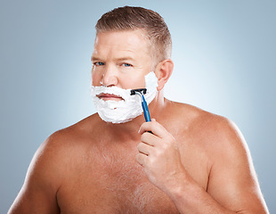 Image showing Portrait, shaving cream and man with razor in studio isolated on a blue background for hair removal. Face, skincare and mature male model with facial foam to shave for aesthetics, health or wellness