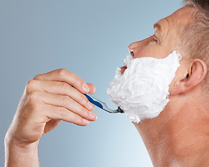 Image showing Razor, face and man with shaving cream in studio isolated on a gray background for hair removal. Profile, skincare and senior male model with facial foam to shave for aesthetics, health or wellness.