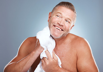 Image showing Happy, old man and skincare in studio with towel for face, cleaning or grooming on grey background. Facial, mature and male model relax for luxury, skin or beauty, wrinkles or treatment and isolated