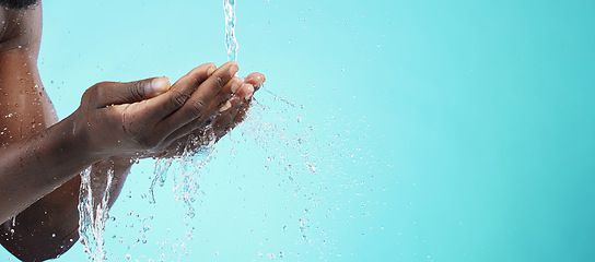 Image showing Water, black man and cleaning hands with mockup space, wash face and skincare isolated on blue background. Healthy skin, clean cosmetics and grooming, hygiene and beauty sustainability in studio