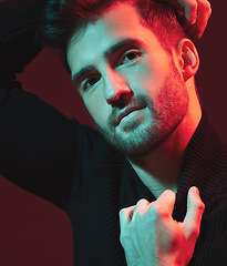 Image showing Man, fashion and face portrait in studio with red light for clothes, beauty and luxury style on dark background. Aesthetic model person hand on turtle neck for art, cosmetics and inspiration for men