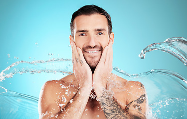 Image showing Water splash, skincare and portrait of man cleaning face, morning treatment isolated on blue background. Facial hygiene, male model and grooming for health, wellness and clean skin care in studio.