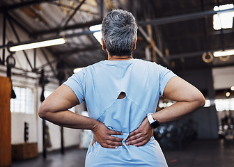 Image showing Back pain, woman and in gym for exercise, fitness and muscle strain with tension, wellness and workout. Female, lady or athlete with injury, medical risk or healthcare with training or sports burnout