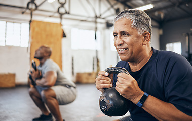 Image showing Training, senior and man exercise with personal trainer at the gym squat with kettlebell equipment for strength. Elderly, old and fitness people workout in a health club for wellness and motivation