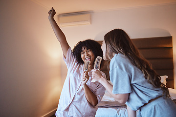 Image showing Women, karaoke and singing in bedroom with brush and pjs, friends get ready for crazy girls night out, music concert and happiness. Girl, friend and happy smile, girlfriends at sleepover in pajamas.