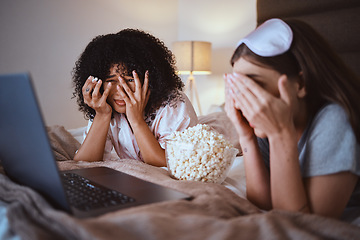 Image showing Women, horror or laptop movie in house bedroom on subscription channel, popcorn entertainment or streaming app. Scared, friends or hand on face on bed, scary technology cinema or relax home bonding