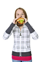 Image showing Teenage girl eating big hamburger