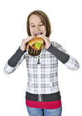 Image showing Teenage girl eating big hamburger
