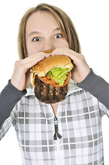 Image showing Teenage girl eating big hamburger