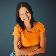 Image showing Portrait, fashion and arms crossed with a woman in studio on a gray background for confidence or positive attitude. Happy, smile and confident with an attractive young female posing indoor for style