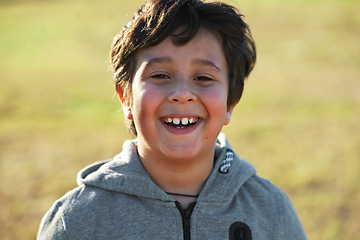 Image showing Happy, smile and portrait of a child in nature having fun while enjoying outdoor fresh air. Happiness, excited and face of a boy kid standing in a park while on a summer vacation, holiday or trip.