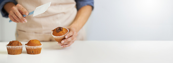 Image showing Chef, cupcakes and person icing muffin with mockup or copy space isolated against a white background. Closeup, hands and cook preparing and decorating dessert or treat on a kitchen table