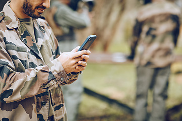 Image showing Chat, typing and man with a phone in the army for communication, social media and contact. Website, email and person reading a message on a mobile app while playing paintball on a field with friends