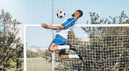 Image showing Sports, soccer and man jump with ball playing game, training and exercise on outdoor field. Fitness, workout and male football player for defence, goalkeeper and in action for goals in competition