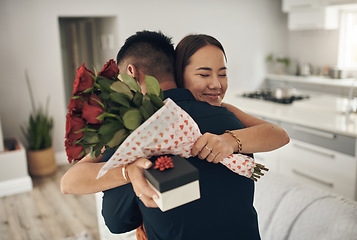 Image showing Couple hug, present and roses surprise of an Asian woman with gift on valentines day. Living room, rose bouquet and lounge of people with love, care and happiness together with a smile from present