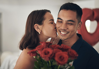 Image showing Love, flowers and valentines day with a couple kissing in their home, in celebration of romance. Dating, rose bouquet or surprise with a man and woman in a house to kiss while bonding in intimacy