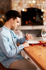 Image showing Romance, waiting and man checking the time while sitting in the restaurant for a valentines day date. Fine dining, late and guy by the table for dinner reservation for anniversary or romantic event.