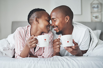 Image showing Love, valentines day and black couple gift cups lying in bed in the morning drinking coffee in the bedroom together. Kiss, romantic and happy lovers relax in a home, house or apartment on holiday