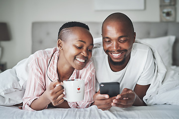 Image showing Black couple in bed with phone, coffee and happiness with morning routine, social media or streaming online. Wifi, communication and technology with happy man and woman, relax at home together